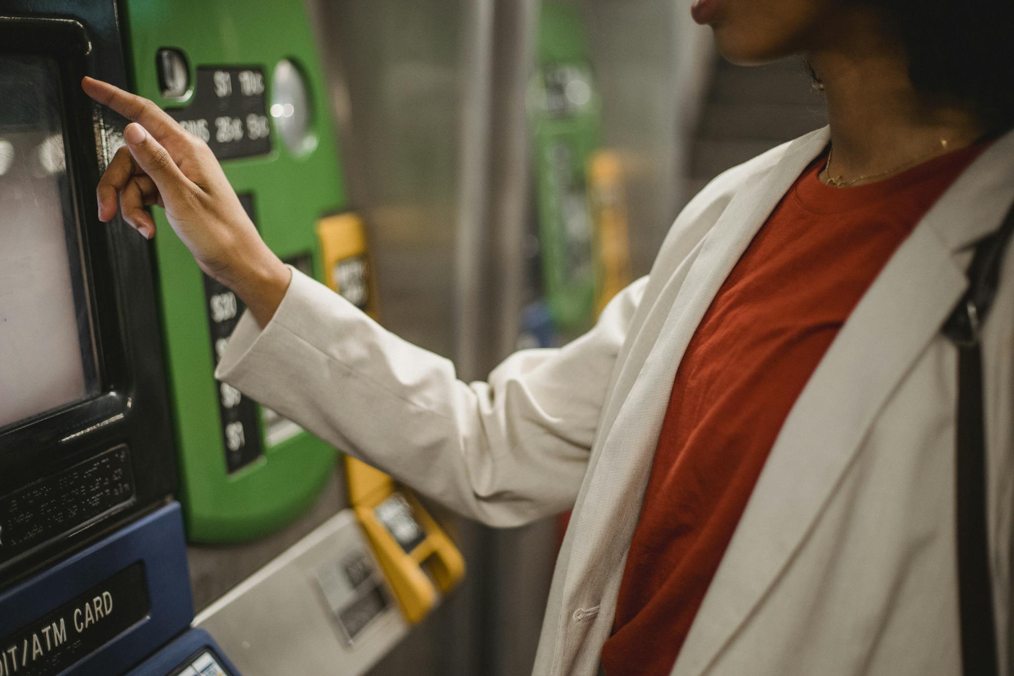 A woman interacts with a ticket machine in a transportation station, highlighting modern convenience.
